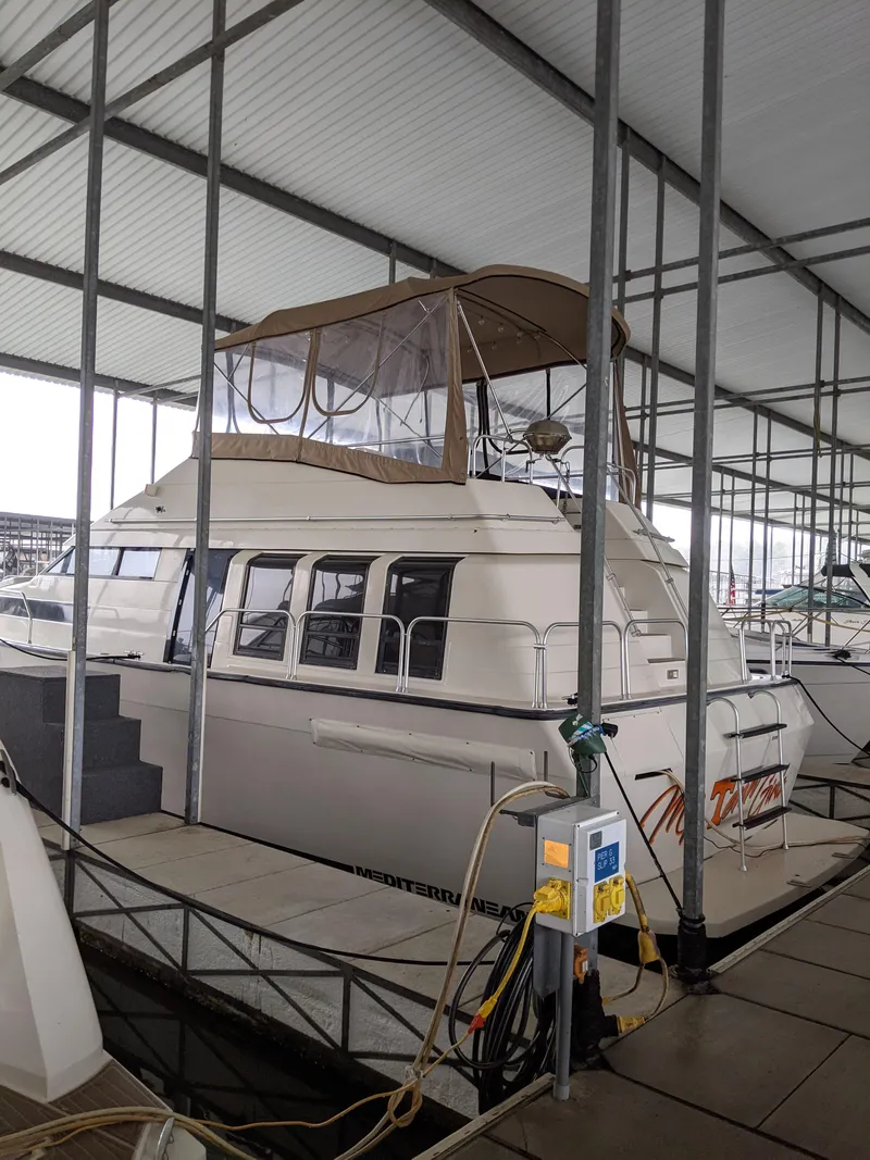 Slide: The Image of 1989 Mainship 41 Grand Salon yacht docked in a covered marina. - 23