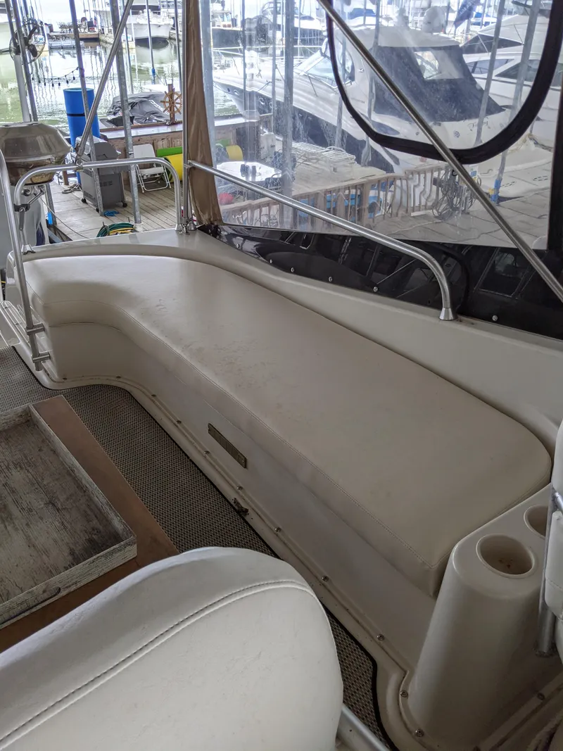 Slide: The Image of 1989 Mainship 41 Grand Salon boat interior with cushioned seating and marina view. - 28