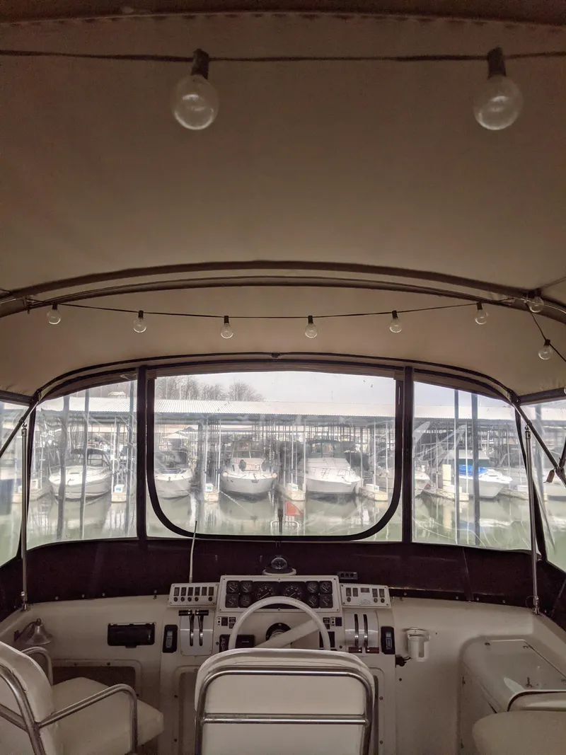 Slide: The Image of 1989 Mainship 41 Grand Salon helm with marina view, featuring classic controls and seating. - 30