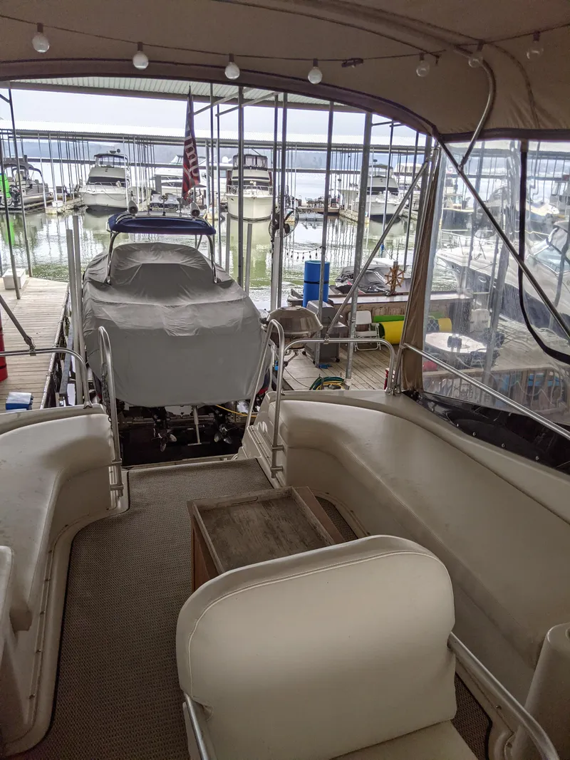 Slide: The Image of 1989 Mainship 41 Grand Salon interior with docked boats in marina background. - 36