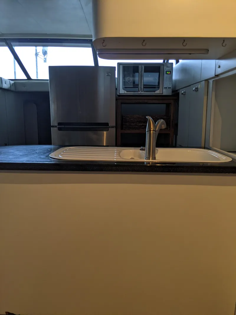 Slide: The Image of 1989 Mainship 41 Grand Salon kitchen with sink, fridge, and microwave. - 47