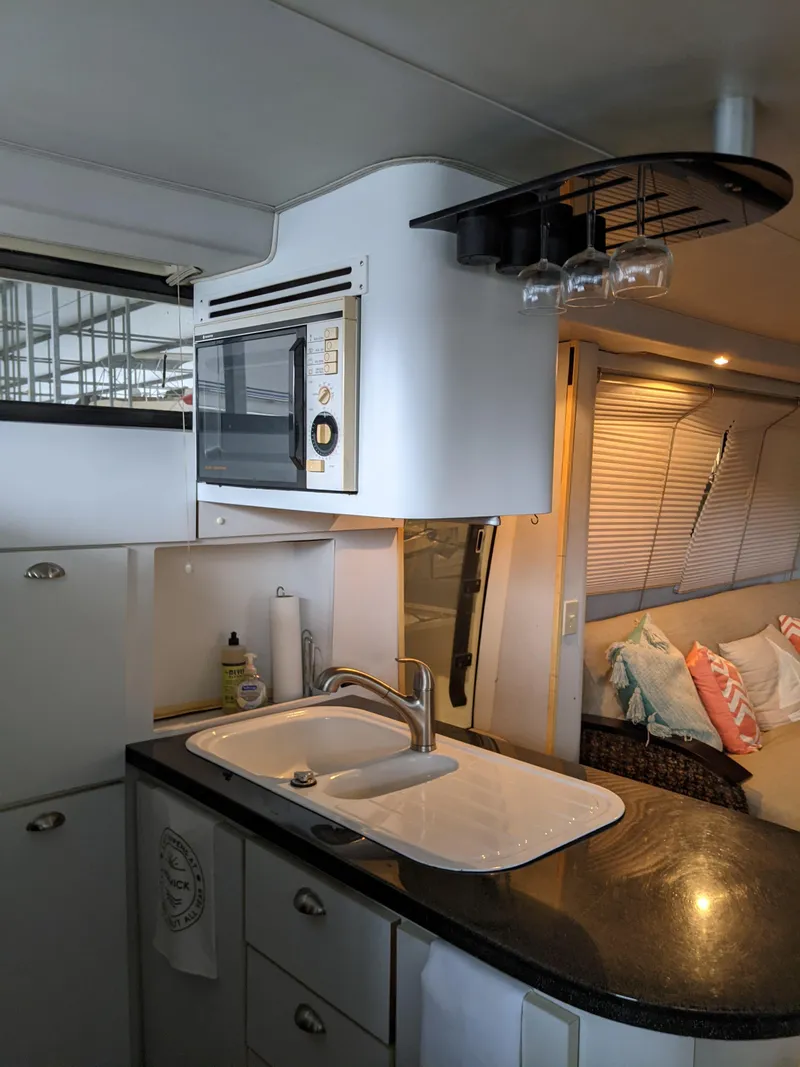 Slide: The Image of 1989 Mainship 41 Grand Salon kitchen with sink, microwave, and glass rack. - 48
