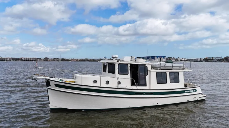 The Image of 2001 Nordic Tug 37 boat on calm water under a partly cloudy sky. - 0