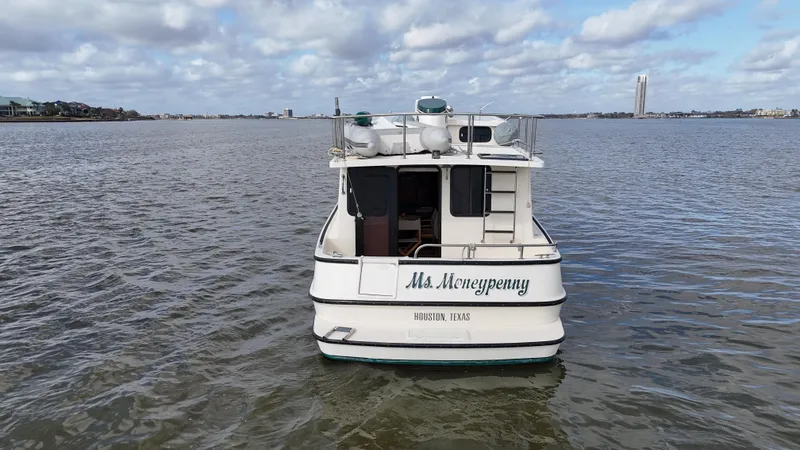Slide: The Image of 2001 Nordic Tug 37 boat named "Ms. Moneypenny" on open water under a cloudy sky. - 12