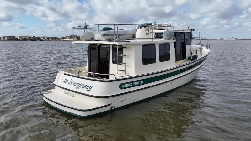 Slide: The Image of 2001 Nordic Tug 37 boat on calm water under a cloudy sky. - 13