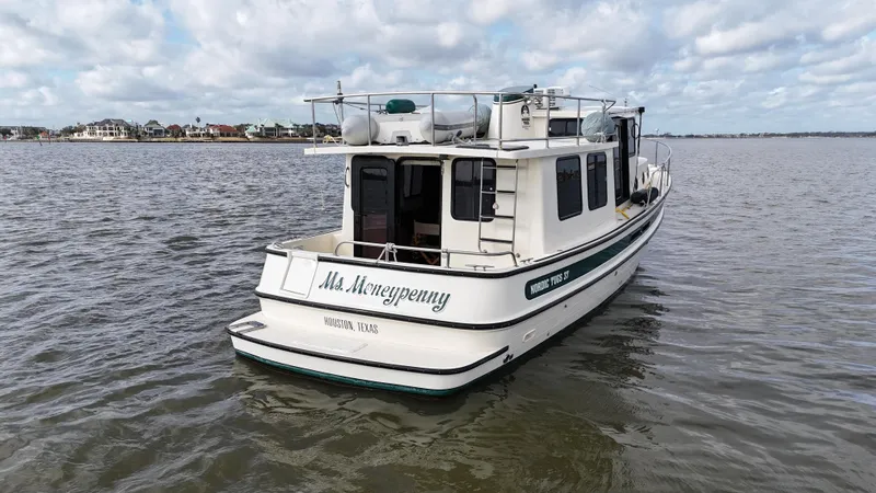 Slide: The Image of 2001 Nordic Tug 37 boat on water, overcast sky, rear view. - 14