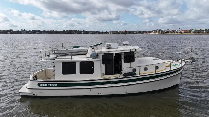 Slide: The Image of 2001 Nordic Tug 37 boat on calm water under a cloudy sky. - 15