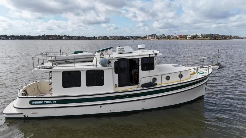 Slide: The Image of 2001 Nordic Tug 37 boat on calm water under a cloudy sky. - 16