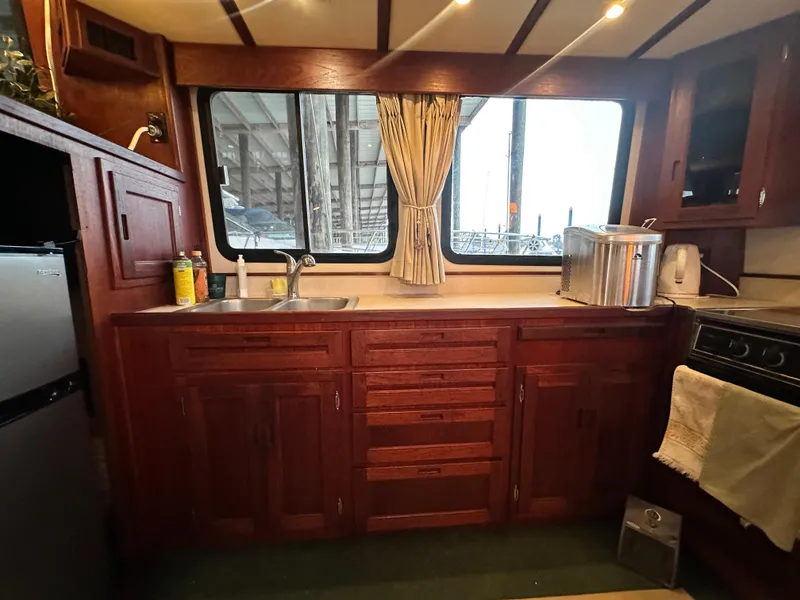 Slide: The Image of Interior of 2001 Nordic Tug 37, featuring a wooden kitchen with sink and stove. - 24
