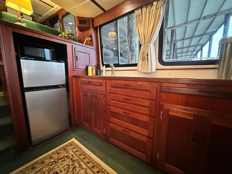 Slide: The Image of Interior of a 2001 Nordic Tug 37, featuring wooden cabinetry and a compact refrigerator. - 28