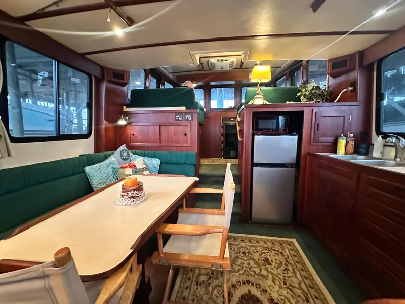 Slide: The Image of Interior of a 2001 Nordic Tug 37, featuring a cozy dining area and compact kitchen. - 29