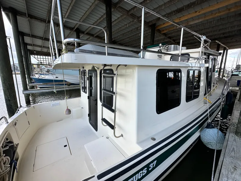Slide: The Image of 2001 Nordic Tug 37 docked under a covered marina. - 3