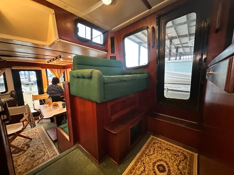 Slide: The Image of Interior of 2001 Nordic Tug 37, featuring cozy seating and wooden accents. - 31