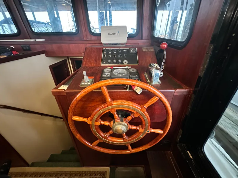 Slide: The Image of 2001 Nordic Tug 37 helm with wooden wheel and navigation controls. - 34
