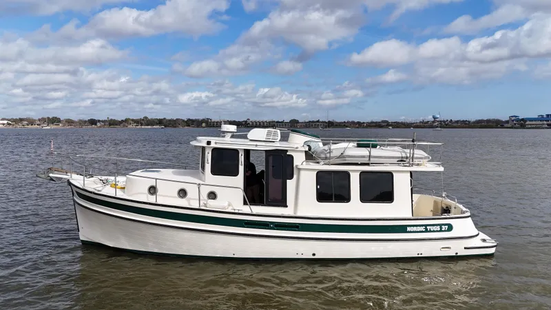 Slide: The Image of 2001 Nordic Tug 37 boat on calm water under a partly cloudy sky. - 4