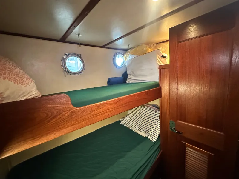Slide: The Image of Bunk beds in 2001 Nordic Tug 37 cabin with portholes and wooden door. - 44