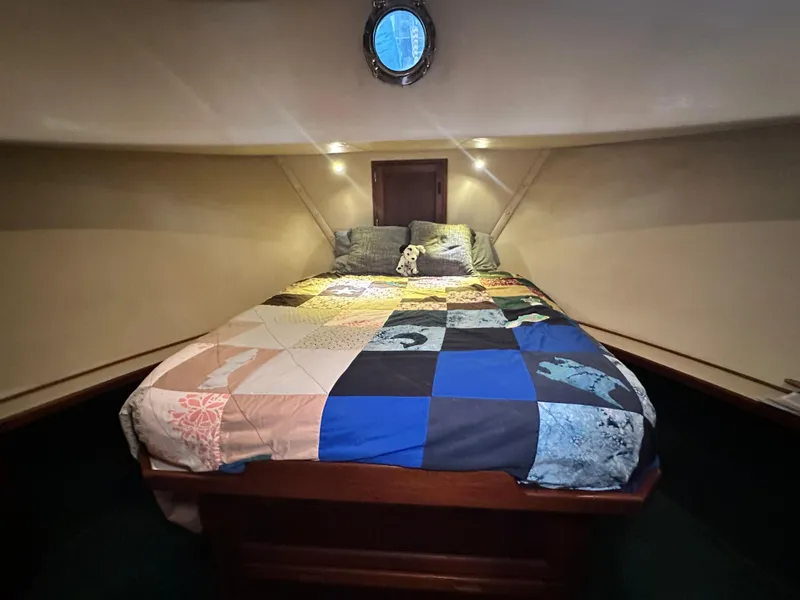 Slide: The Image of Cozy cabin interior of 2001 Nordic Tug 37 with a colorful patchwork quilt. - 46