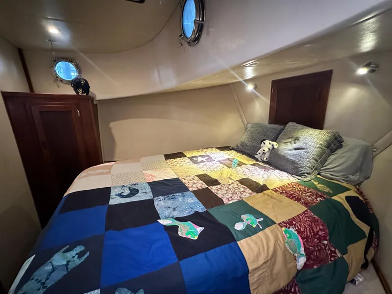 Slide: The Image of Cozy cabin interior of 2001 Nordic Tug 37 with colorful patchwork quilt on bed. - 48