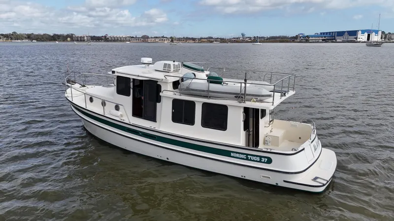 Slide: The Image of 2001 Nordic Tug 37 boat on calm water, side view with clear sky background. - 5