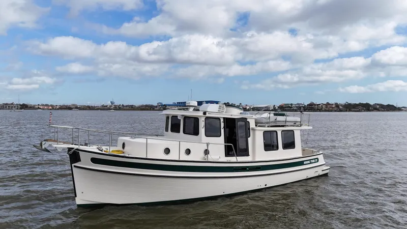 Slide: The Image of 2001 Nordic Tug 37 cruising on calm waters under a partly cloudy sky. - 6