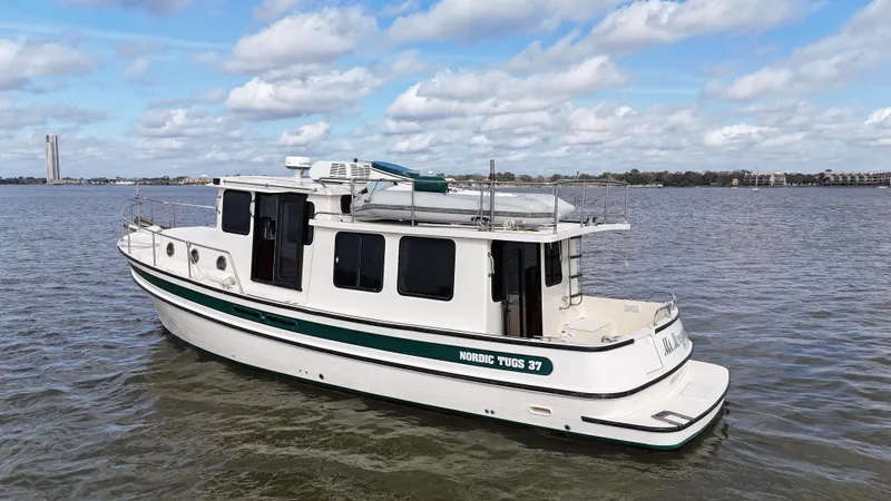 Slide: The Image of 2001 Nordic Tug 37 boat on calm water under a partly cloudy sky. - 7