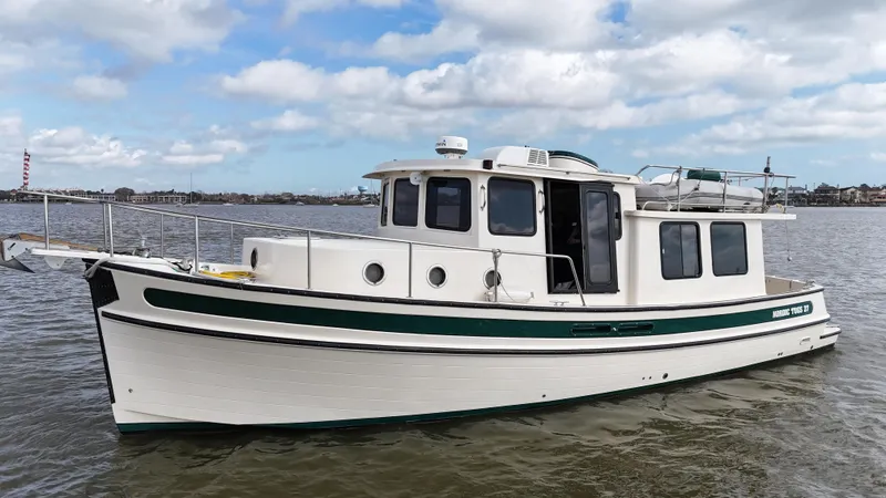 Slide: The Image of 2001 Nordic Tug 37 boat on water, featuring classic design and sturdy build. - 8