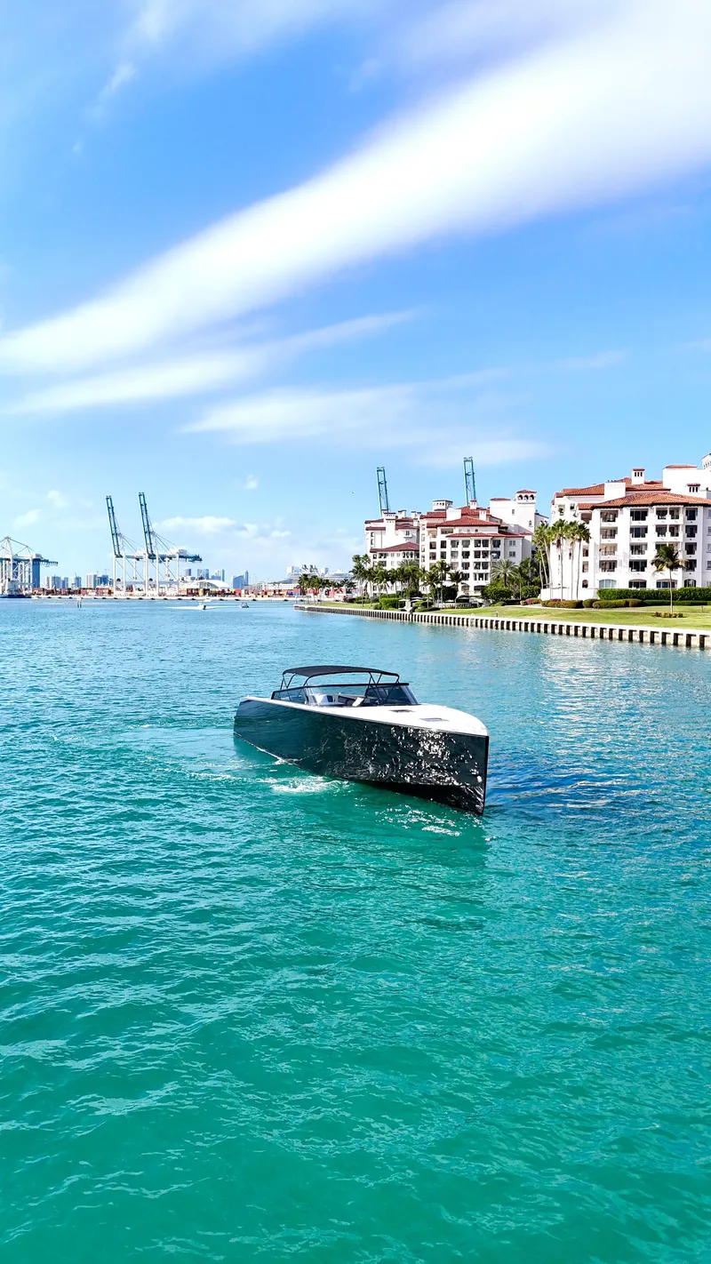 Slide: The Image of VanDutch 55 yacht cruising in turquoise waters near luxury waterfront buildings, 2014 model. - 15