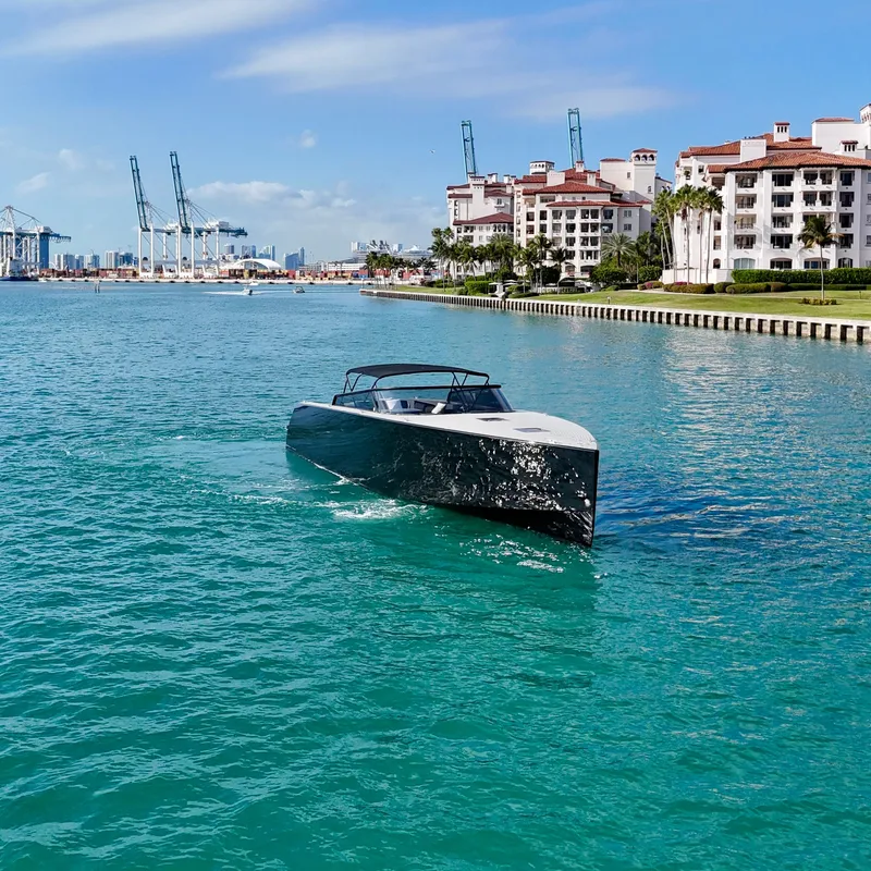 Slide: The Image of VanDutch 55 yacht cruising near waterfront buildings, clear blue water, sunny day, 2014 model. - 16