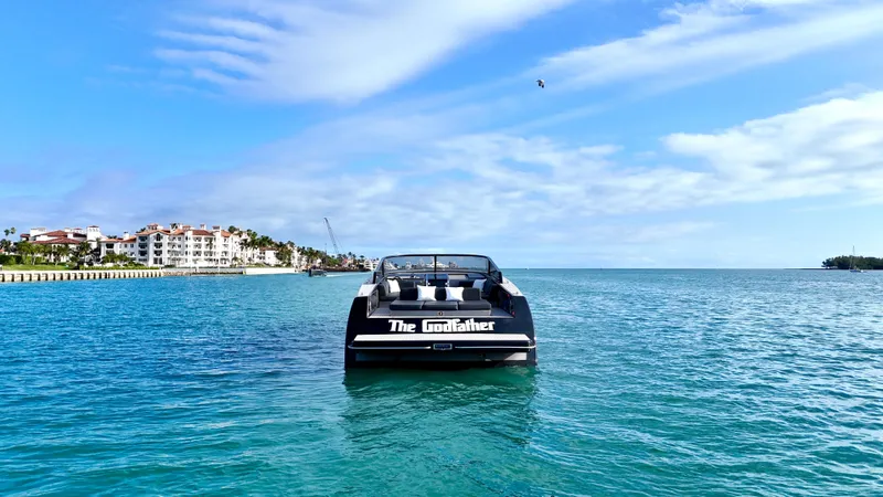 Slide: The Image of 2014 VanDutch 55 yacht named "The Godfather" on serene blue waters, coastal buildings in background. - 33