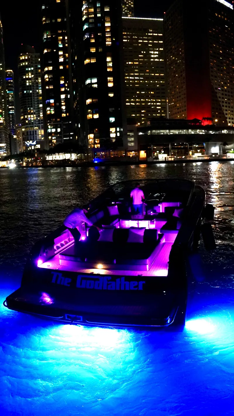 Slide: The Image of VanDutch 55 yacht with vibrant lights against city skyline at night, 2014 model. - 42