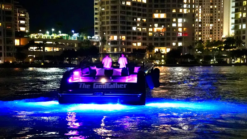 Slide: The Image of VanDutch 55 yacht, 2014 model, illuminated at night with vibrant blue lights on the water. - 43