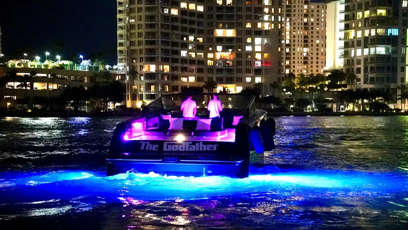 Slide: The Image of VanDutch 55 yacht with vibrant lights on water at night, city skyline in background. - 45
