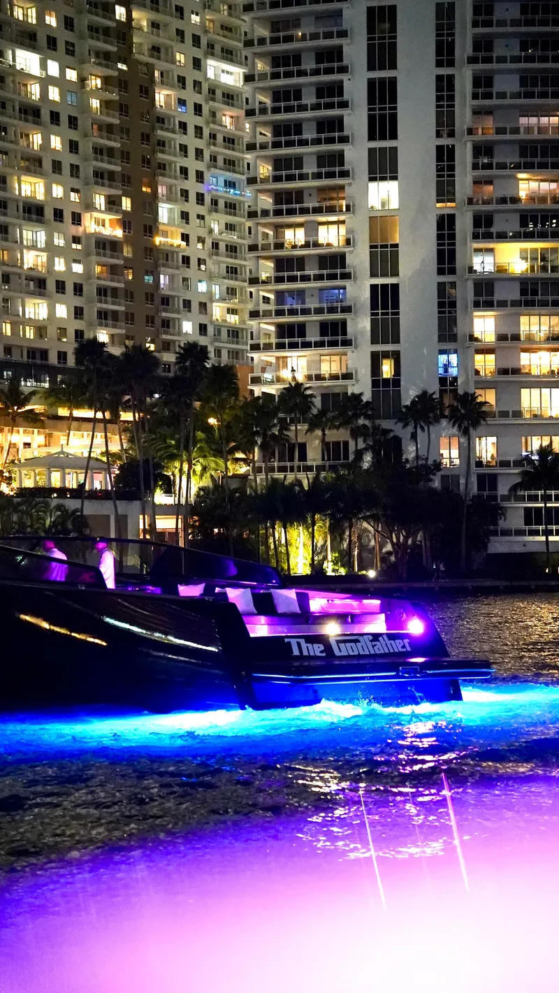 Slide: The Image of VanDutch 55 yacht with vibrant lights against city skyline at night, 2014 model. - 48