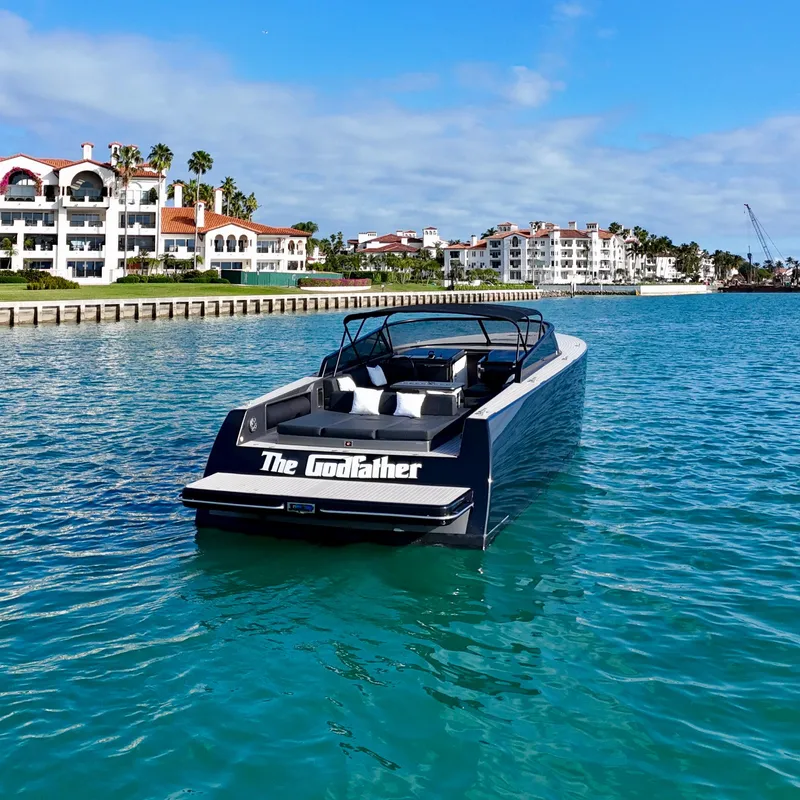 Slide: The Image of 2014 VanDutch 55 yacht named "The Godfather" on turquoise water near luxury waterfront homes. - 8