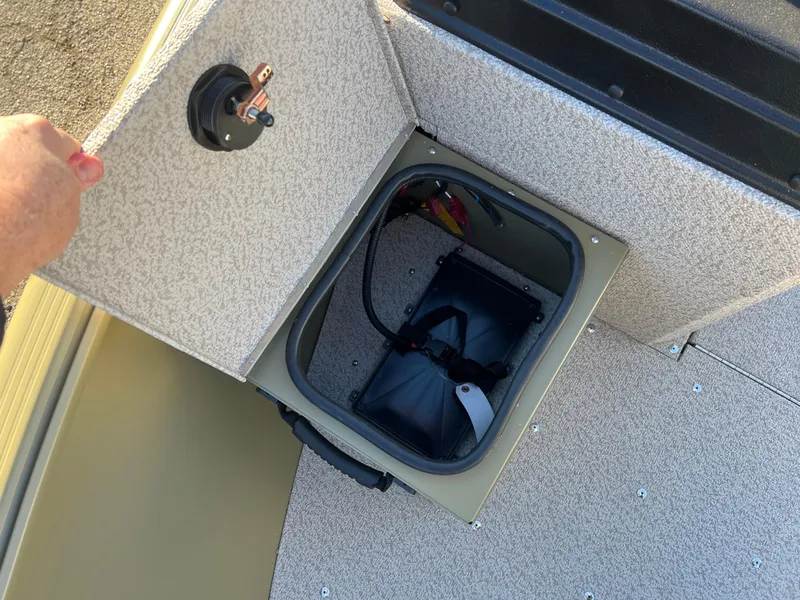 Slide: The Image of 2025 Lund 1875 Alaskan SS boat storage compartment with open lid, showing interior details. - 10