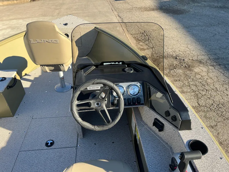 Slide: The Image of 2025 Lund 1875 Alaskan SS boat interior with steering wheel and dashboard controls. - 15