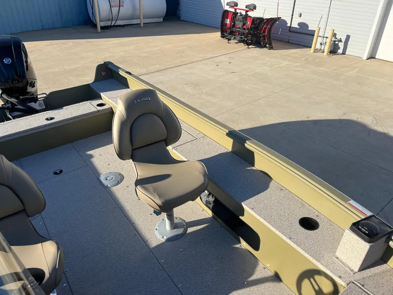 Slide: The Image of 2025 Lund 1875 Alaskan SS boat interior with beige seating and spacious deck. - 16