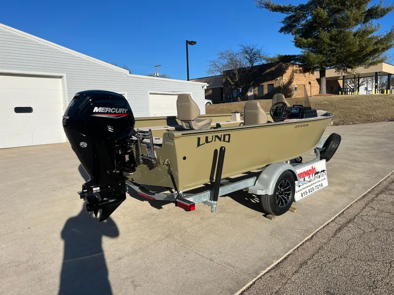 Slide: The Image of 2025 Lund 1875 Alaskan SS boat with Mercury engine on trailer, parked outdoors. - 6