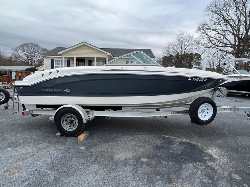 Slide: The Image of 2014 Chaparral 19 Sport H2O boat on trailer, parked outdoors near a house. - 1