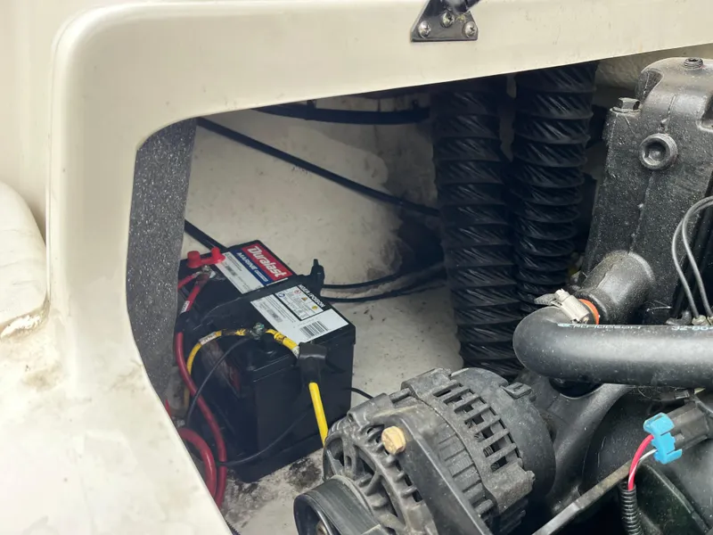 Slide: The Image of Engine compartment of a 2014 Chaparral 19 Sport H2O with visible battery and components. - 12