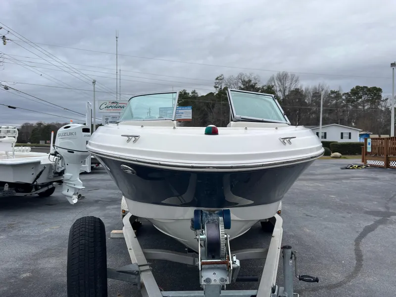 Slide: The Image of 2014 Chaparral 19 Sport H2O boat on trailer, parked outdoors under cloudy sky. - 3