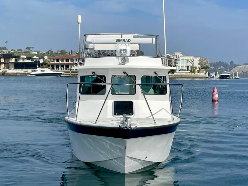 Slide: The Image of Farallon 2800 Whaleback boat, 2012 model, on calm water with coastal background. - 1