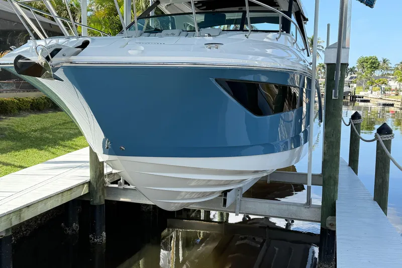 Slide: The Image of 2020 Sea Ray 32 Sundancer Outboard boat on lift, dockside view. - 0