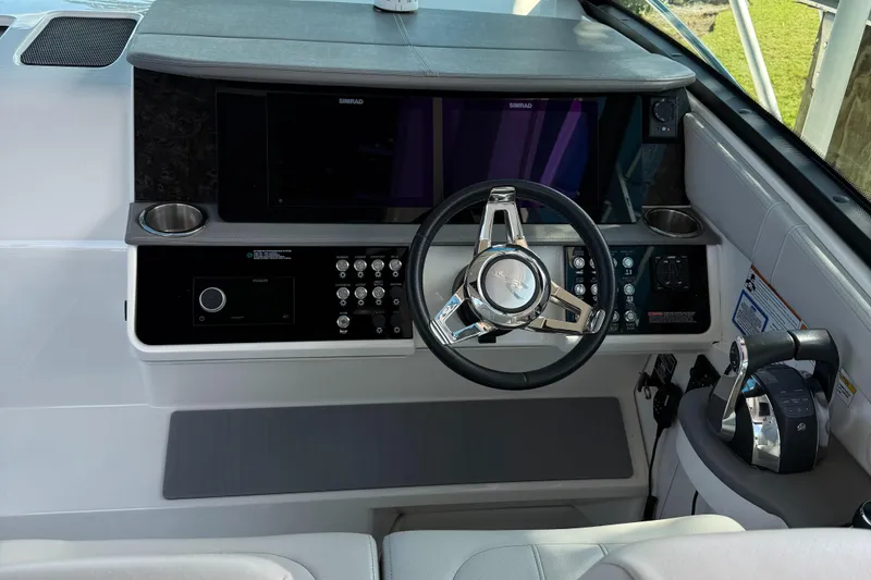 Slide: The Image of 2020 Sea Ray 32 Sundancer Outboard helm with modern controls and steering wheel. - 18