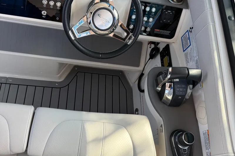 Slide: The Image of Interior cockpit of 2020 Sea Ray 32 Sundancer Outboard, featuring steering wheel and controls. - 19