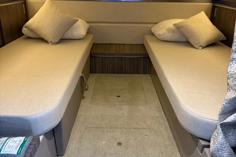 Slide: The Image of 2020 Sea Ray 32 Sundancer Outboard cabin with twin beds and beige cushions. - 8
