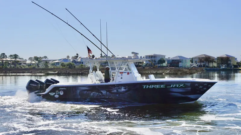 Slide: The Image of Invincible 35 Catamaran 2021 on water, featuring "THREE JAX" design, with fishing rods and engines. - 4