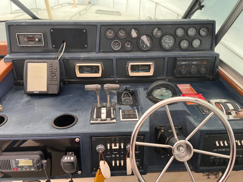 Slide: The Image of 1989 Sea Ray 390 Express Cruiser helm with steering wheel and control panel. - 10