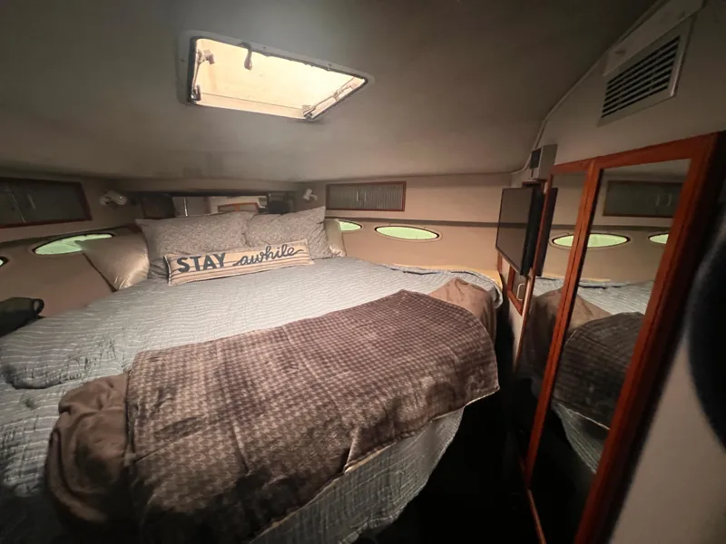 Slide: The Image of 1989 Sea Ray 390 Express Cruiser cabin with cozy bed and nautical decor. - 19
