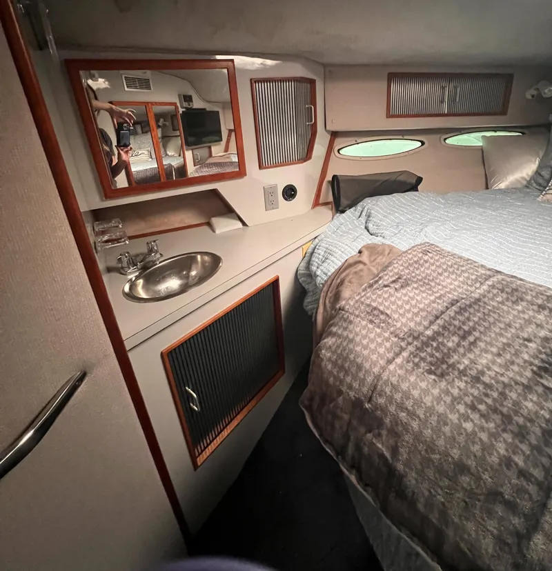Slide: The Image of Cozy cabin interior of 1989 Sea Ray 390 Express Cruiser with bed and mirror. - 20